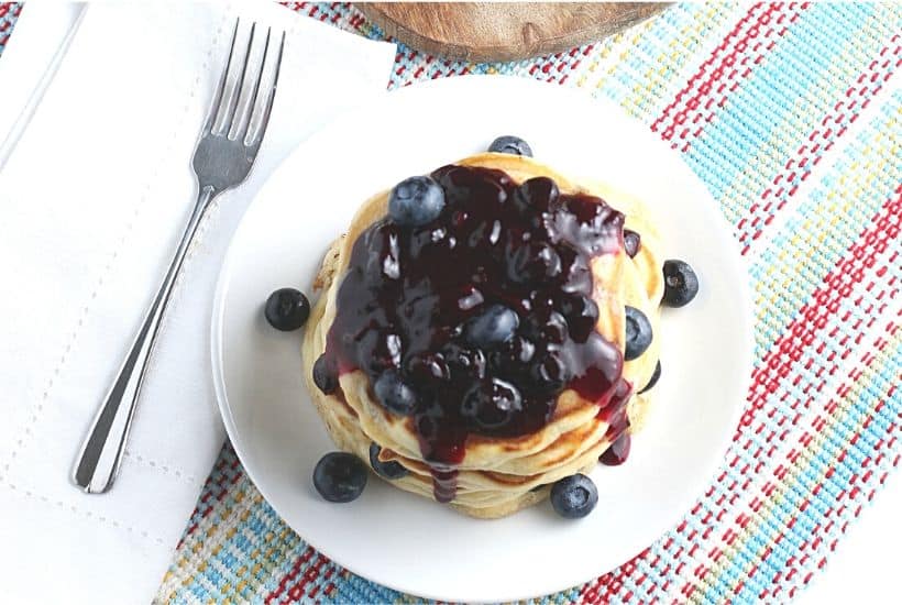 Start your morning off with a delicious batch of Blueberry Buttermilk Pancakes from scratch. This light and fluffy blueberry pancake recipe is perfect for blueberry season or all year round. Top this easy blueberry pancake recipe with homemade blueberry sauce for some extra blueberry flavor. Your family will love this easy buttermilk pancake recipe from scratch.