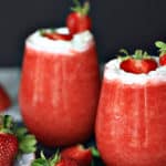 Cheers to Strawberry season. With just a few simple ingredients, you can make your own Strawberry Shortcake Daiquiris at home. Skip the mix and make fresh strawberry daiquiris at home using this easy recipe. It's the perfect slushy cocktail for cooling down in warmer weather! #strawberrydaiquiri #cocktails #slush