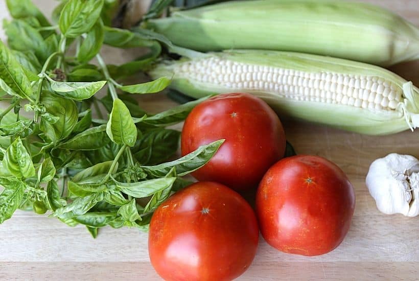 Garden fresh tomatoes, corn, and basil pair up to form the perfect trio in this Tomato Corn And Basil Salad! This easy summer salad recipe is delicious. This is also an easy make-ahead salad recipe you can serve at a party.