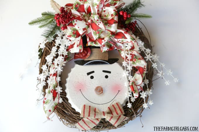 Brighten your Christmas decor with this simple DIY Jolly Snowman Christmas Wreath. This holiday craft idea is perfect hanging on a door at home.