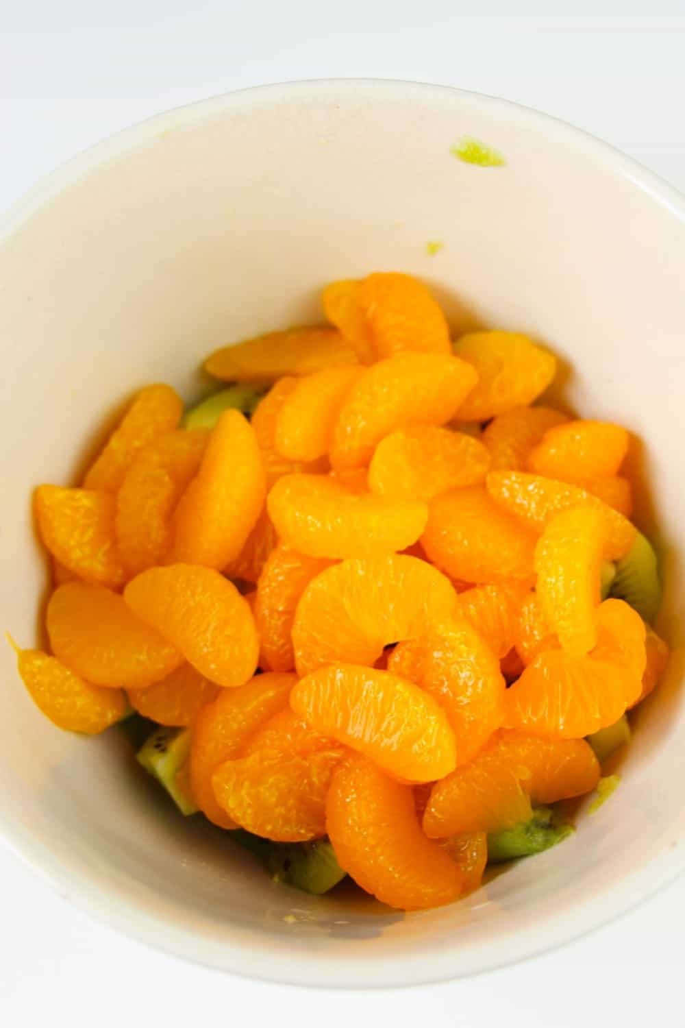 This easy Kiwi Fruit Salad With Honey Citrus Dressing recipe is perfect to enjoy any time of the year. The optional honey citrus dressing adds the perfect amount of sweetness. #fruitsalad #kiwi #mandarinorange #dessert #healthyrecipe
