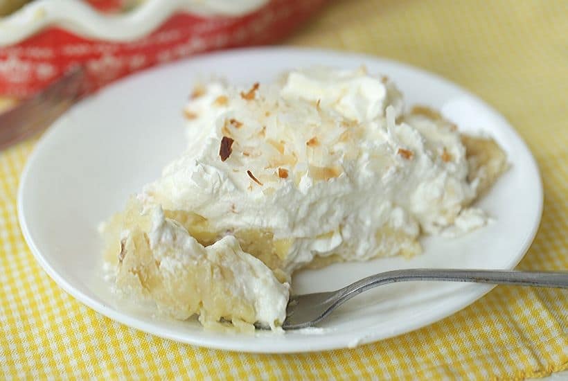 You can't go wrong with a slice of this luscious Coconut Cream Pie. This Best Coconut Custard pie recipe has a creamy coconut custard filling and topped with sweet whipped cream. All of this is nestled into a buttery, flaky pie crust. This easy pie recipe is perfect to serve all year long. #coconutcustardpie #pierecipe #easypierecipe #nobakedessert