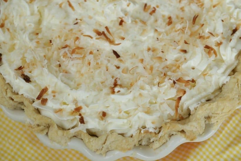 You can't go wrong with a slice of this luscious Coconut Cream Pie. This Best Coconut Custard pie recipe has a creamy coconut custard filling and topped with sweet whipped cream. All of this is nestled into a buttery, flaky pie crust. This easy pie recipe is perfect to serve all year long. #coconutcustardpie #pierecipe #easypierecipe #nobakedessert