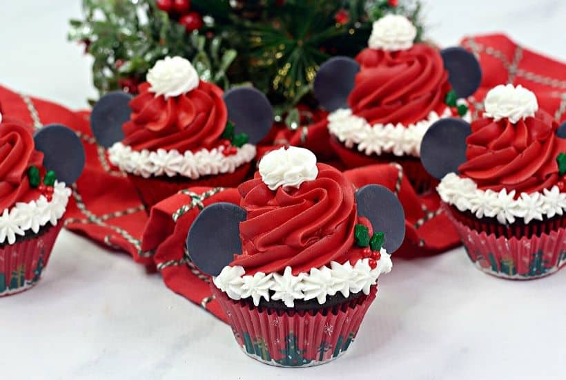 Make this Christmas a Disney Christmas. These adorable Mickey Mouse Santa Cupcakes are the perfect holiday Disney snack to celebrate Christmas. This Disney dessert is so easy and festive. Add a cute Mickey Santa hat to these decorated Christmas cupcakes. #disneysnack #christmascupake #disneyfood