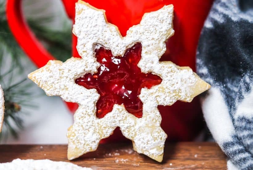 This Classic Linzer Cookies recipe will totally be your jam (no pun intended). Win your Christmas Cookie Swap with this delicious cookie recipe. This traditional Linzer sandwich cookie recipe is full of buttery almond flavor and filled with sweet raspberry jam. #chrismtascookie #cookieswap #linzercookies