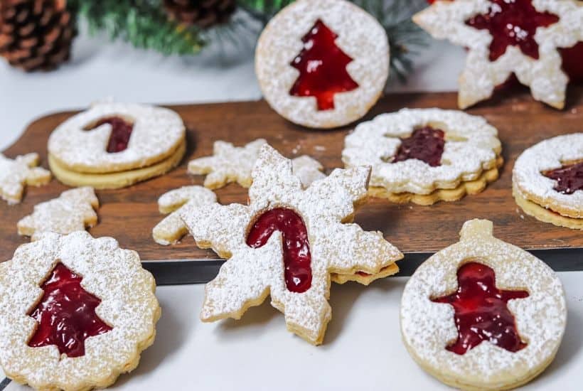 This Classic Linzer Cookies recipe will totally be your jam (no pun intended). Win your Christmas Cookie Swap with this delicious cookie recipe. This traditional Linzer sandwich cookie recipe is full of buttery almond flavor and filled with sweet raspberry jam. #chrismtascookie #cookieswap #linzercookies
