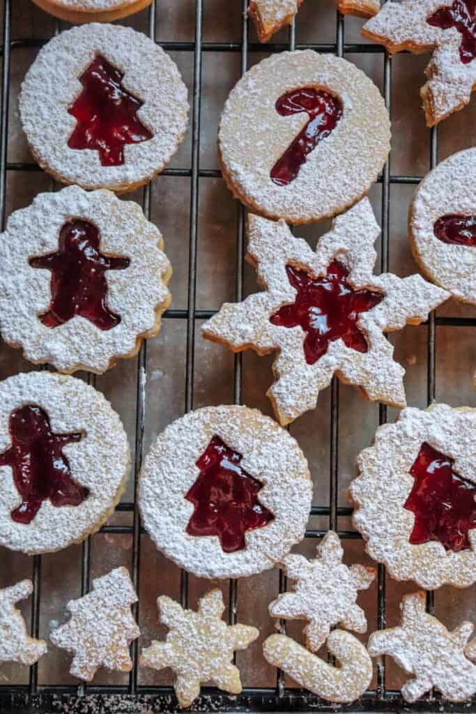 This Classic Linzer Cookies recipe will totally be your jam (no pun intended). Win your Christmas Cookie Swap with this delicious cookie recipe. This traditional Linzer sandwich cookie recipe is full of buttery almond flavor and filled with sweet raspberry jam. #chrismtascookie #cookieswap #linzercookies