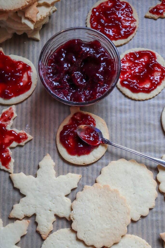 This Classic Linzer Cookies recipe will totally be your jam (no pun intended). Win your Christmas Cookie Swap with this delicious cookie recipe. This traditional Linzer sandwich cookie recipe is full of buttery almond flavor and filled with sweet raspberry jam. #chrismtascookie #cookieswap #linzercookies