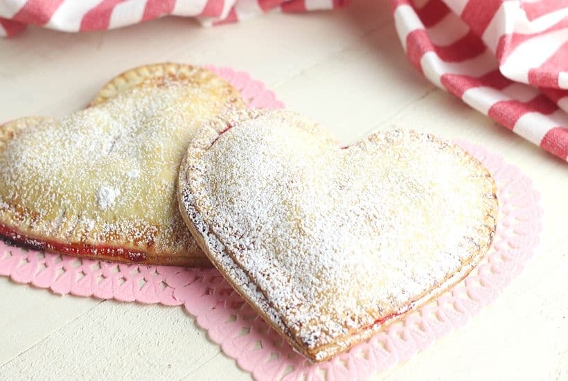 These Heart-Shaped Cherry Hand Pies are the perfect snack. Each hand pie is filled with sweet cherry pie filling sandwiched in between a flaky pie crust, then baked to perfection.