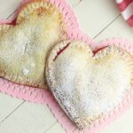 These Heart-Shaped Cherry Hand Pies are the perfect snack. Each hand pie is filled with sweet cherry pie filling sandwiched in between a flaky pie crust, then baked to perfection.