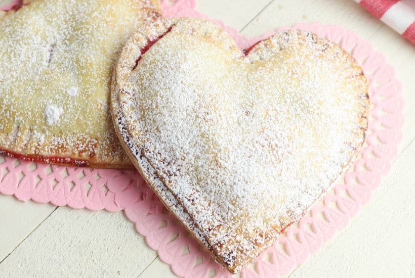 These Heart-Shaped Cherry Hand Pies are the perfect snack. Each hand pie is filled with sweet cherry pie filling sandwiched in between a flaky pie crust, then baked to perfection.