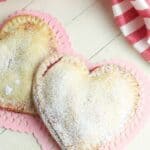 These Heart-Shaped Cherry Hand Pies are the perfect snack. Each hand pie is filled with sweet cherry pie filling sandwiched in between a flaky pie crust, then baked to perfection.