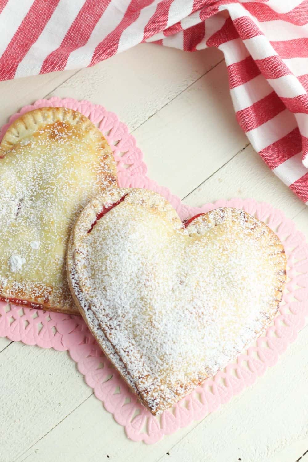 These Heart-Shaped Cherry Hand Pies are the perfect snack. Each hand pie is filled with sweet cherry pie filling sandwiched in between a flaky pie crust, then baked to perfection.
