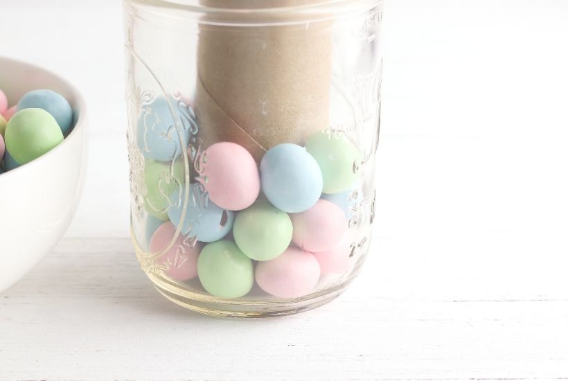 Add a touch of spring to your dining table. This easy Easter Candy Mason Jar Flower Vase is so easy to create. Grab so Easter candy and a mason jar and start crafting. You can make this easy holiday craft in just minutes. #eastercraft #holidaycraft