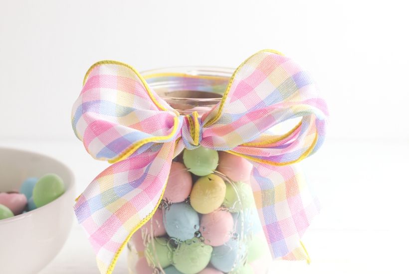 Add a touch of spring to your dining table. This easy Easter Candy Mason Jar Flower Vase is so easy to create. Grab so Easter candy and a mason jar and start crafting. You can make this easy holiday craft in just minutes. #eastercraft #holidaycraft