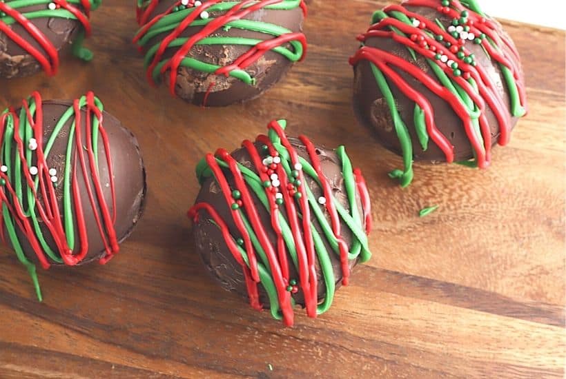 Ready for an indulgent treat? This Hot Chocolate Bombs Recipe is rich and filled with hot chocolate, marshmallow and sprinkle surprises inside. What is a hot chocolate bomb? A Hot cocoa bomb is a chocolate shell that is filled with hot cocoa, marshmallows and other hot chocolate add ins. Download the free Christmas printable gift bag toppers and give these as a Christmas food gift.