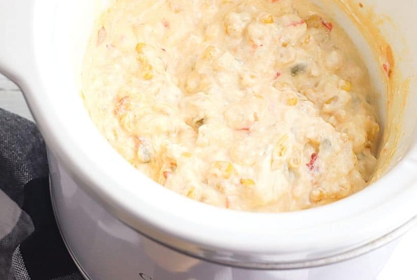 This Cheesy Slow Cooker Fiesta Corn Dip is a creamy, cheesy dip recipe that's perfect for any party. It's great for tailgating, too!