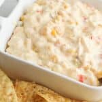 This Cheesy Slow Cooker Fiesta Corn Dip is a creamy, cheesy dip recipe that's perfect for any party. It's great for tailgating, too!