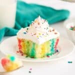 Make a colorful, moist, and utterly delicious cake within minutes with this Rainbow Poke Cake recipe. It is full of flavor and plenty of fun colors, including shades of pink, blue, and yellow!