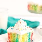Make a colorful, moist, and utterly delicious cake within minutes with this Rainbow Poke Cake recipe. It is full of flavor and plenty of fun colors, including shades of pink, blue, and yellow!