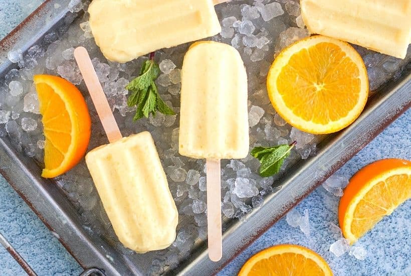 Orange Julius Popsicles are creamy, smooth, and full of orange flavor. If you love an orange creamsicle, you are going to love this variation of the classic frozen treat. This Copycat Orange Julius Pops Recipe is perfect for a hot summer day. Try this homemade orange creamsicle recipe today.