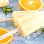 Orange Julius Popsicles are creamy, smooth, and full of orange flavor. If you love an orange creamsicle, you are going to love this variation of the classic frozen treat. This Copycat Orange Julius Pops Recipe is perfect for a hot summer day. Try this homemade orange creamsicle recipe today.