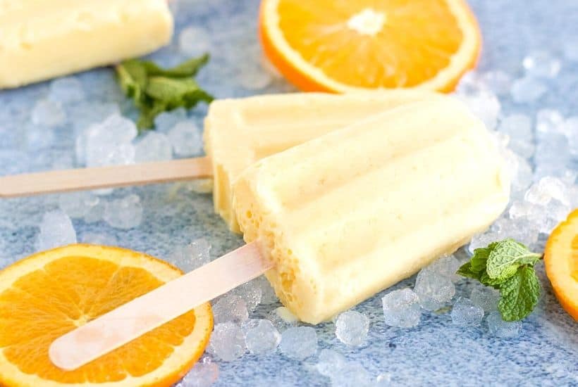 Orange Julius Popsicles are creamy, smooth, and full of orange flavor. If you love an orange creamsicle, you are going to love this variation of the classic frozen treat. This Copycat Orange Julius Pops Recipe is perfect for a hot summer day. Try this homemade orange creamsicle recipe today.