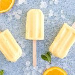 Orange Julius Popsicles are creamy, smooth, and full of orange flavor. If you love an orange creamsicle, you are going to love this variation of the classic frozen treat. This Copycat Orange Julius Pops Recipe is perfect for a hot summer day. Try this homemade orange creamsicle recipe today.