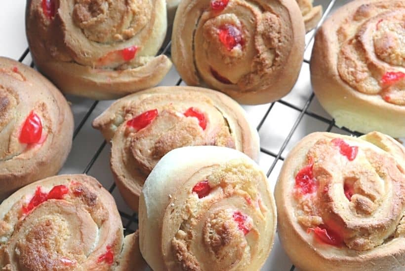 If you love eating baked goods for breakfast, try this Swedish Breakfast Rolls Recipe. These rolls are sweet, soft, fluffy, and perfect to eat for a quick grab and go breakfast. This easy Swedish breakfast bun recipe is consists of a sweet dough flavored with cardamon. Almonds and cherries are added and the sweet rolls are topped with a delicious icing glaze.