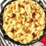 Ditch the box of macaroni and cheese and make a cheesy side on the stovetop with this stovetop Bacon Mac and Cheese recipe. It’s simple, flavorful, and perfect to serve with some of your favorite entrees, such as chicken and pork! This stovetop macaroni and cheese recipe is a perfect weeknight meal idea. Your family will love this creamy mac and cheese recipe. This is the mac & cheese is the ultimate comfort food recipe.
