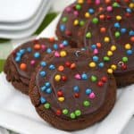A chocolatey cookie with a chocolate ganache topping and colorful rainbow chips on top will be a showstopper in not only the presentation but in taste! Chocolate lovers definitely need to try this unique and delicious recipe for copycat Crumbl Cosmic Brownie Cookies.