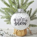 Who says you need the most expensive ornaments to make your Christmas tree look amazing? Learn how to easily create the most beautiful Let It Snow Ornament to hang on the tree or give as a gift. This DIY Ornament is an easy holiday Cricut Craft Idea. It is a great homemade Christmas gift craft idea.