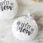 Who says you need the most expensive ornaments to make your Christmas tree look amazing? Learn how to easily create the most beautiful Let It Snow Ornament to hang on the tree or give as a gift. This DIY Ornament is an easy holiday Cricut Craft Idea. It is a great homemade Christmas gift craft idea.
