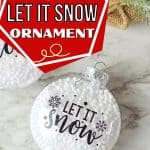 Who says you need the most expensive ornaments to make your Christmas tree look amazing? Learn how to easily create the most beautiful Let It Snow Ornament to hang on the tree or give as a gift. This DIY Ornament is an easy holiday Cricut Craft Idea. It is a great homemade Christmas gift craft idea.
