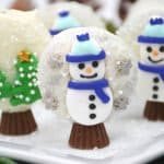 Prepare perfectly decorated Snowman Snow Globe Cookies for the holidays. These sweet, decorative holiday cookies are a must-have for children and adults. This easy cookie recipe is made with OREOS. These chocolate covered OREOS are a fun Christmas Cookie recipe to make and share.