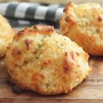 The next time you’re craving those cheesy biscuits from the popular seafood chain, ditch the trip to the restaurant and prepare these Copycat Red Lobster Cheddar Bay Biscuits instead. They’re easy, cheesy, and absolutely delicious! These Copycat Red Lobster Cheddar Bay Biscuits are more than delicious, they are scrumptious. You can make them right at home.