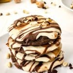 These Soft & Chewy Snickers Cookies are a delightful treat that has all the flavors of a Snickers bar. The double chocolate cookies are soft and chewy while the nougat whipped frosting adds a totally different chewy element. Topped with melted caramel, chocolate, and peanuts, these Snickers cookies truly are the perfect sweet treat.